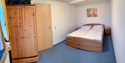 1 dormitorio pequeño con 1 cama y armario de madera en "Ferienhof Alte Mühle" W 1 en Bannesdorf