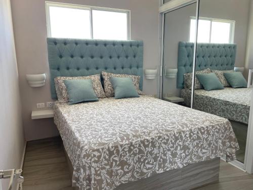 a bedroom with a large bed and a mirror at Apartamentos La Torre in Río San Juan