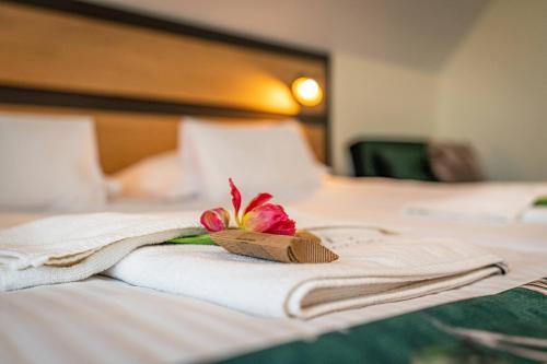 a hotel room with a towel and a flower on a bed at Rezydencja Markowy Dworek in Białka Tatrzanska