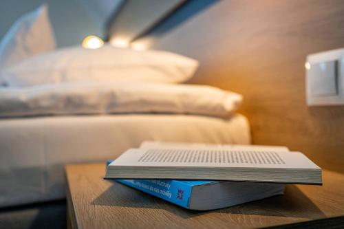 a book sitting on top of a table with a bed at Rezydencja Markowy Dworek in Białka Tatrzanska