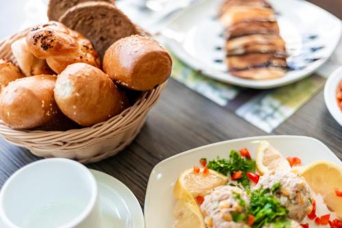 a table with plates of bread and a basket of food at Aviv Holiday Flat in Tiberias