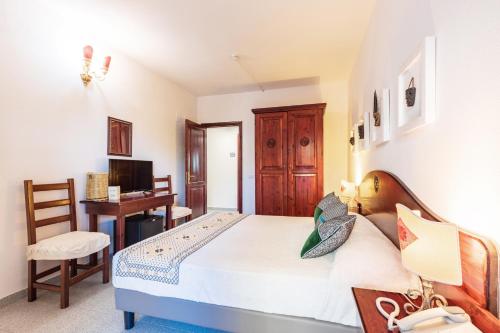 Letto o letti in una camera di Hotel S'Ortale Possibilità di Parcheggio interno e Ristorante all'aperto