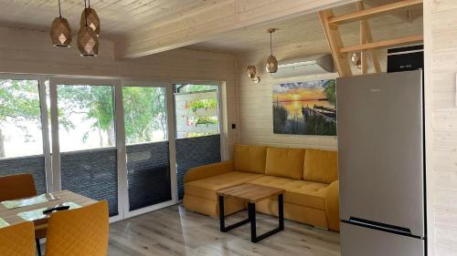 a living room with a couch and a table at Domki Mili Lubie Gudowo Jezioro Lubie in Drawsko Pomorskie
