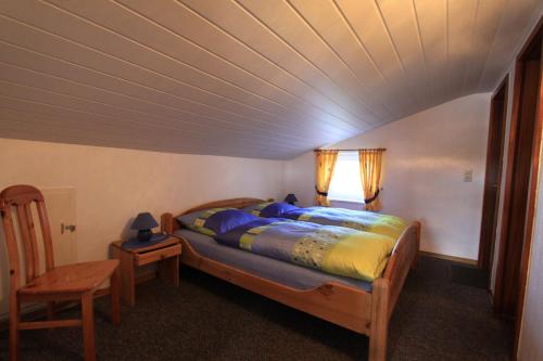 a bedroom with a bed and a table and a chair at "Ferienhof Alte Mühle" W 1a in Bannesdorf