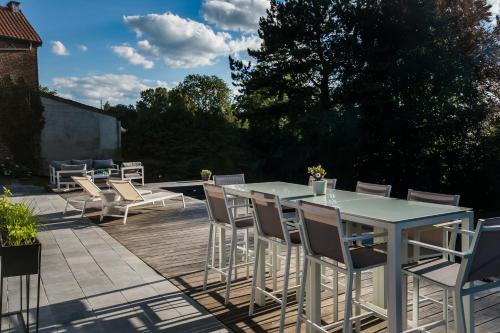 a patio with tables and chairs on a deck at Au Calme de Hosdent in Braives