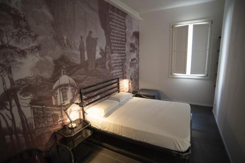 um quarto com uma cama com um mural na parede em BB LETTERARIO em Ravenna