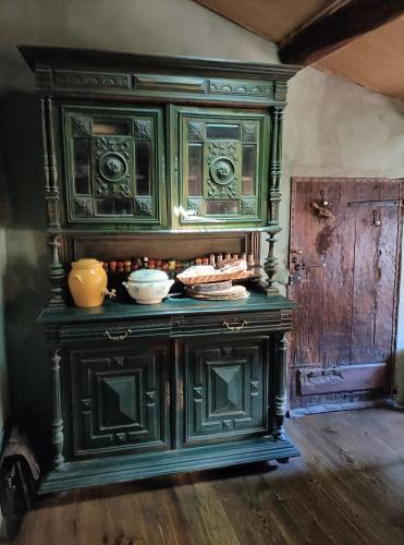 an old green cabinet with bowls on top of it at Entre Terre et Ciel. in Saignon