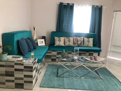 a living room with a blue couch and a table at Apartamentos La Torre in Río San Juan