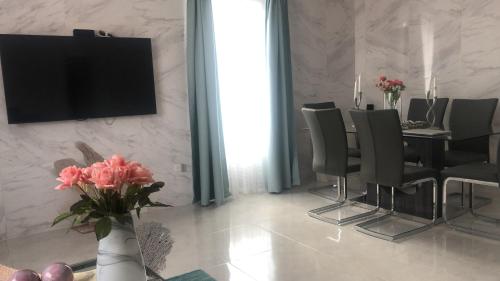 a dining room with a table and a television on a wall at Apartamentos La Torre in Río San Juan