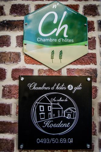 a sign on a brick wall with a house at Au Calme de Hosdent in Braives