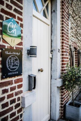 a door to a brick building with a sign on it at Au Calme de Hosdent in Braives
