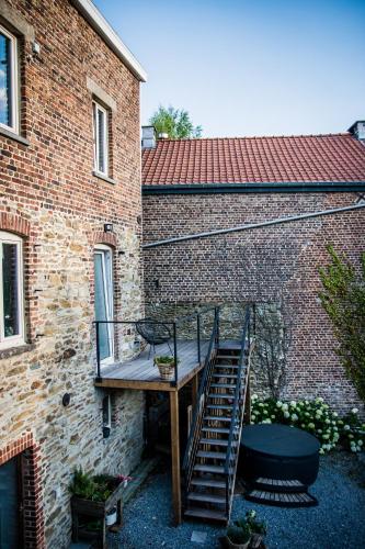 a staircase leading to a brick building with a balcony at Au Calme de Hosdent in Braives