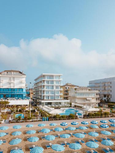 a bunch of umbrellas on a beach with buildings at Hotel Galassia Suites & Spa in Lido di Jesolo