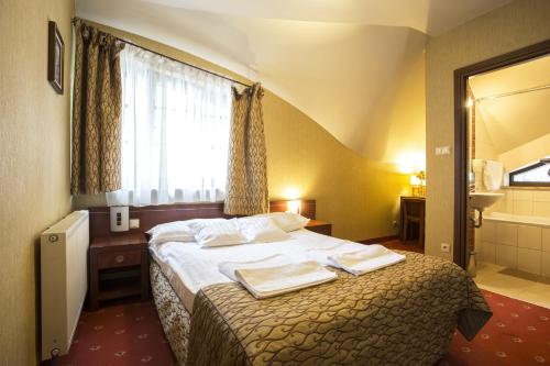 a hotel room with a bed with towels on it at Hotel Restauracja Browar Lwów w Lublinie in Lublin