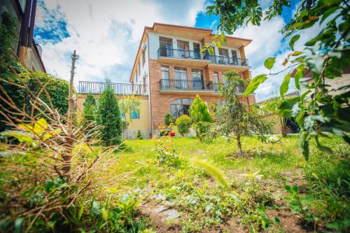 Cette maison en briques dispose d'un balcon au-dessus d'une cour. dans l'établissement Hotel mia Telavi, à Telavi