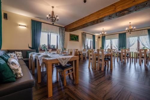 a dining room with wooden tables and chairs at Rezydencja Markowy Dworek in Białka Tatrzanska