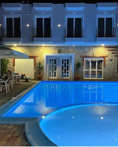 a villa with a swimming pool at night at Hotel Adriatik Orikum in Orikum
