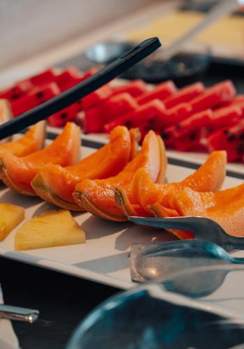 a tray of food with peppers on a table with spoons at Hotel Galassia Suites & Spa in Lido di Jesolo