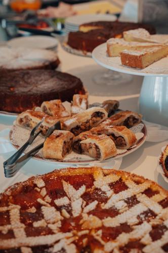 a table with several plates of cakes and pies at Hotel Galassia Suites & Spa in Lido di Jesolo