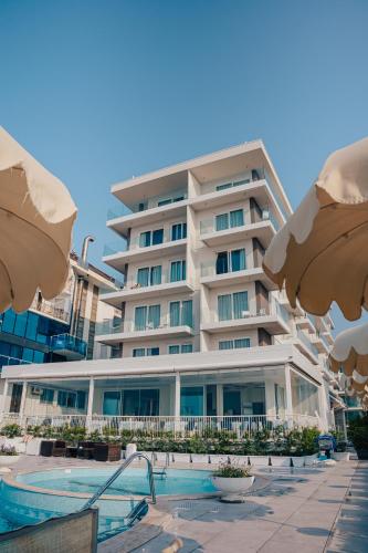 a building with a swimming pool in front of a building at Hotel Galassia Suites & Spa in Lido di Jesolo