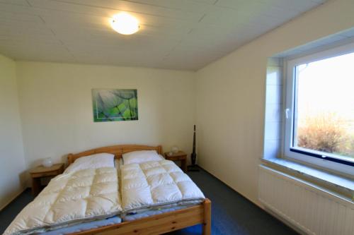 uma cama num quarto com uma grande janela em "Ferienhof Alte Mühle" W 3 em Bannesdorf