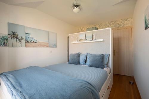 een slaapkamer met een bed met blauwe lakens bij ZURI-sea wiev in Zambratija