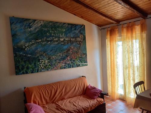 ein Wohnzimmer mit einer Couch und einem Gemälde an der Wand in der Unterkunft Arte Mare e Cultura in Pettineo