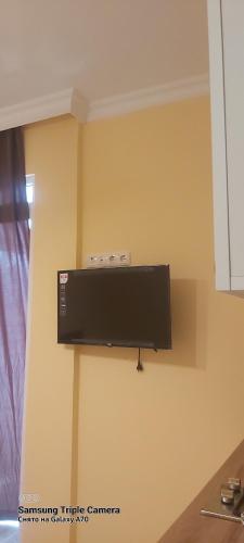 einen Flachbild-TV, der an einer Wand hängt in der Unterkunft Студия с красивым видом на горы in Batumi