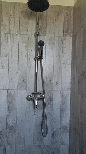 une douche dans une salle de bain avec une pomme de douche dans l'établissement villa du jardin chez mandy, à Magalas