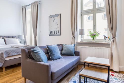 a living room with a couch and a bed at Krakow Central Apartments in Kraków