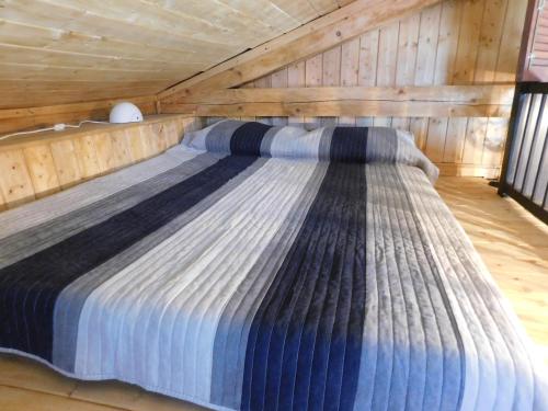 Cama grande en habitación con techo de madera en Kamnita hiša Stari klesar, en Ilirska Bistrica