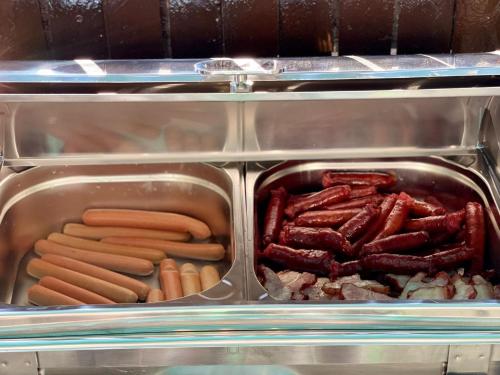 a tray of hot dogs and carrots and meat at Hotel Sweet in Mamaia Sat/Năvodari