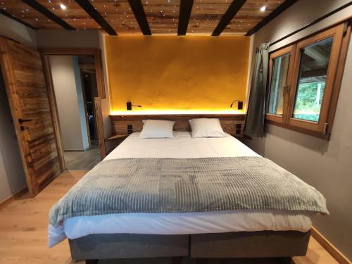 a bedroom with a large bed with a yellow headboard at Le PasSionNant in Morzine