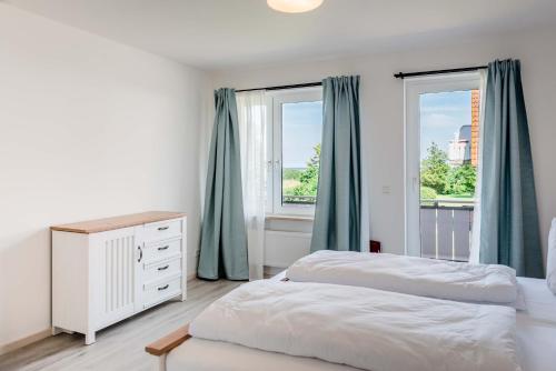 a bedroom with two beds and a window at Strandperle Appartements in Hasselberg