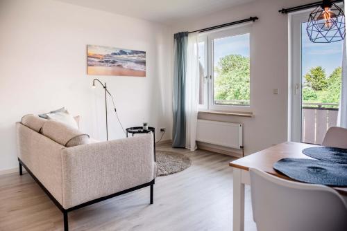 a living room with a couch and a table at Strandperle Appartements in Hasselberg