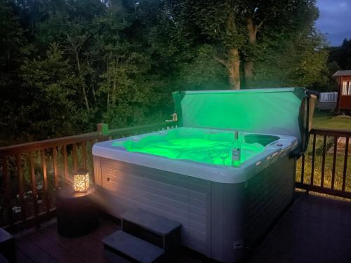 una bañera verde en una terraza por la noche en Carre Retreat with private hot tub, en Felton