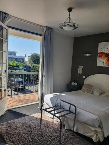 - une chambre avec un lit et un balcon avec vue dans l'établissement Le Petit Manoir Logis, aux Angles (Gard)