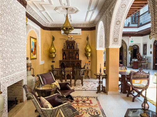 a living room with chairs and a fireplace at Perlekech Riad & Spa in Marrakech