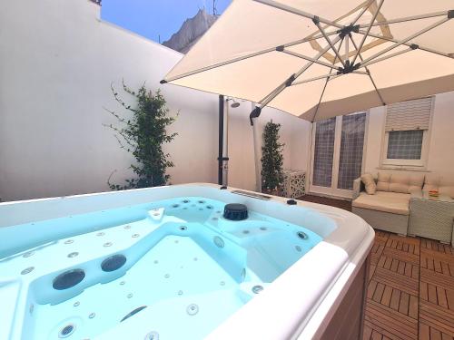 a hot tub with an umbrella on a patio at Tiberio House & Spa in Capri