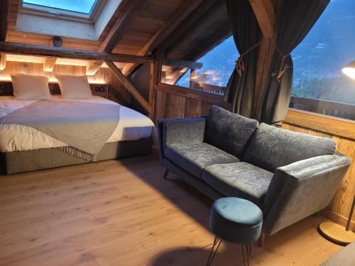 a bedroom with a bed and a couch and a window at Le PasSionNant in Morzine