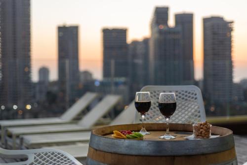 a table with two glasses of wine and a plate of food at Hotel Indigo Tel Aviv - Diamond District by IHG in Tel Aviv