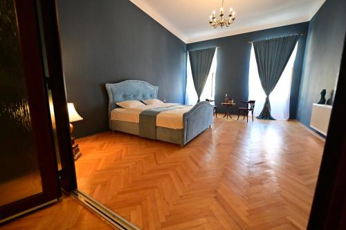 1 dormitorio con 1 cama y suelo de madera en Lovely 2 bedroom apartment in historic city center, en Sibiu