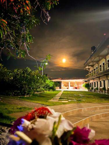 a building at night with flowers in the foreground at La Plumerias in Moalboal
