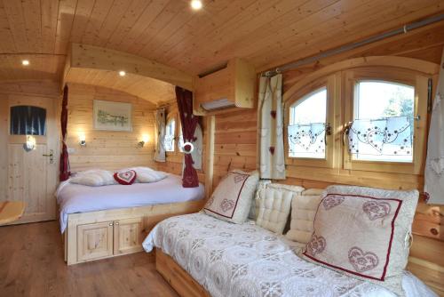 a bedroom in a log cabin with two beds at La Maison Rouge Ladoix - Proche Beaune in Ladoix Serrigny