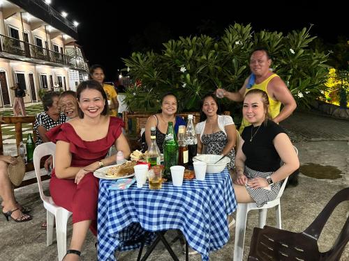 a group of people sitting at a table with drinks at La Plumerias in Moalboal