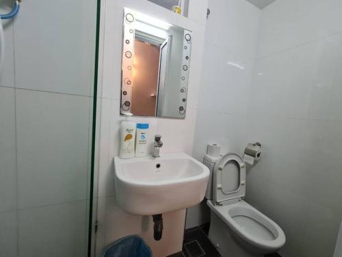 a bathroom with a sink and a toilet and a mirror at Maritime Luxury Duplex 2Bedrooms 6-10pax in Jelutong