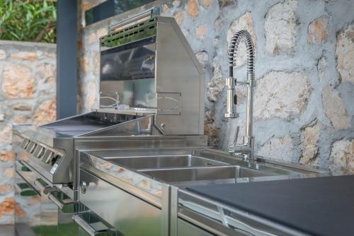 a stainless steel kitchen with a sink and a counter at Deluxe VILLA GRAZIELLA 200 M FROM THE BEACH in Èze