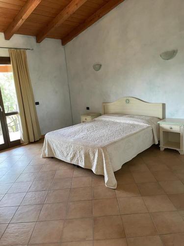 オルビアにあるAgriturismo San Giovanniのタイルフロアのベッドルーム1室(ベッド1台付)