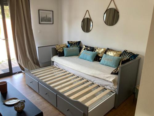 Bett mit blauen Kissen auf einem Zimmer in der Unterkunft Cottage in Pessac