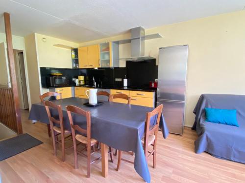 eine Küche und ein Esszimmer mit einem blauen Tisch und Stühlen in der Unterkunft La Mongie - Apt 2 ch - 8 pers - Place parking couvert in La Mongie